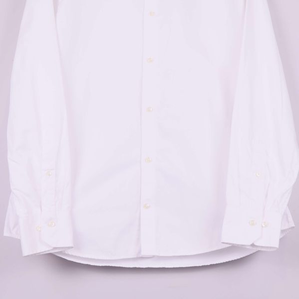 Ärmar och knappar på vit skjorta i närbild