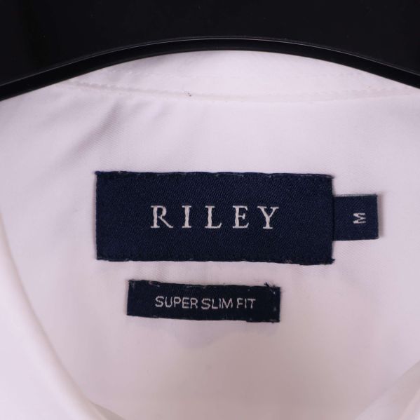 Nära bild på mörkblå Riley-etikett i skjortan