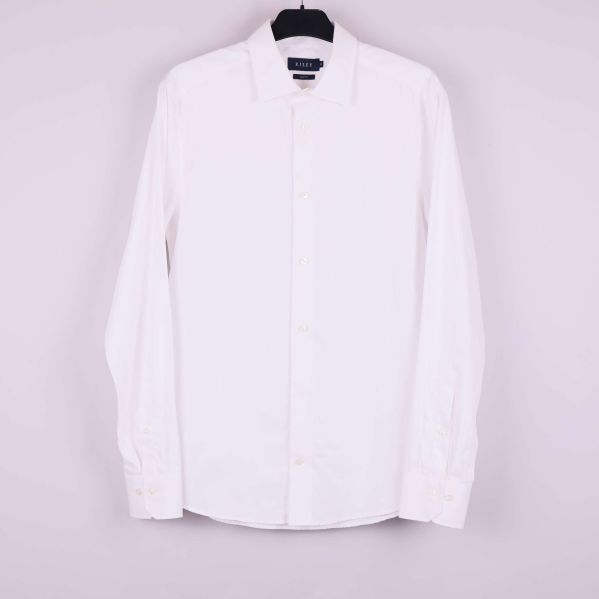 Helvit skjorta med lång ärm hängande på en galge