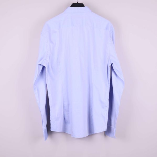 Ljusblå skjorta på galge bakifrån