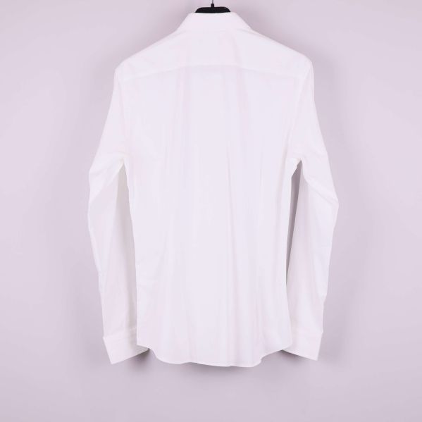 Vit skjorta visad bakifrån på galge