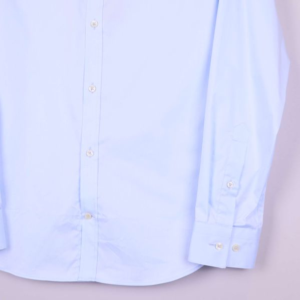 Närbild nedre delen av ljusblå skjorta med manschetter
