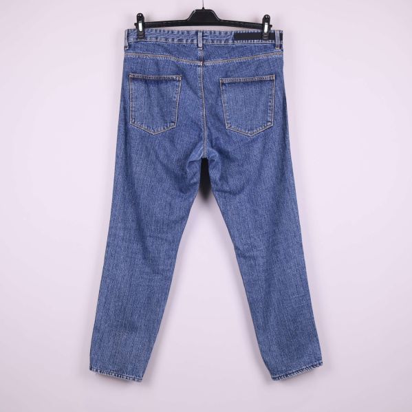 Blå raka jeans visade bakifrån med två bakfickor