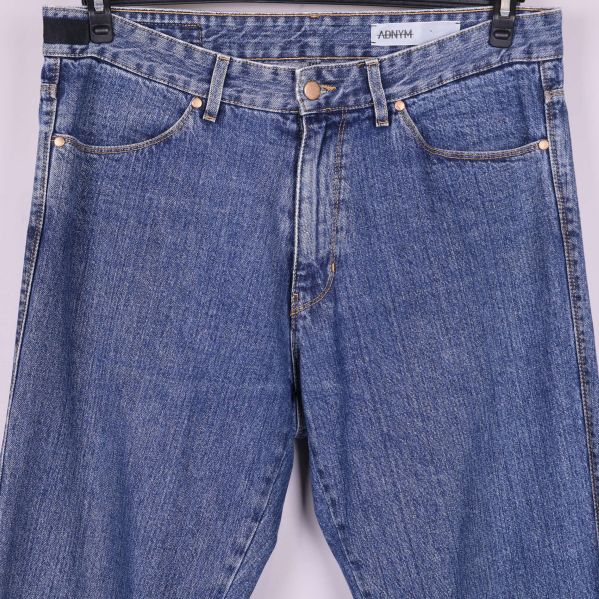 Närbild på jeansens midja, bälteshällor och knäppning