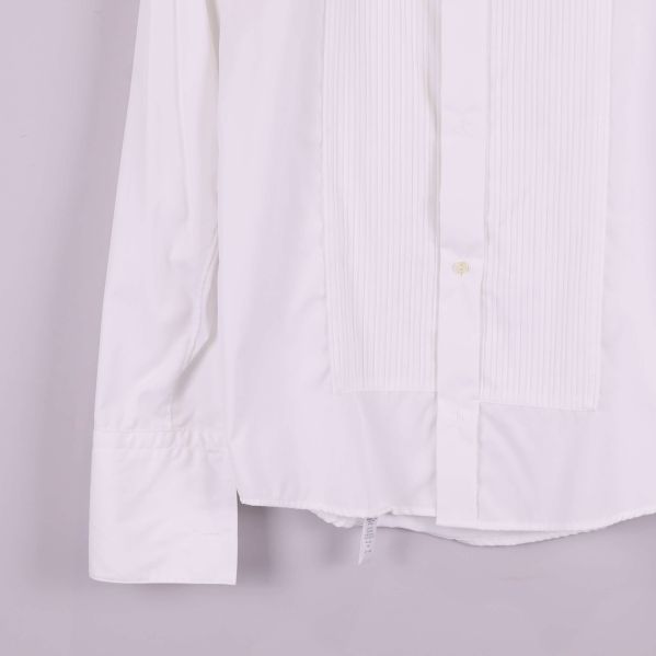 Närbild på skjortans nederkant och ärm med plissering