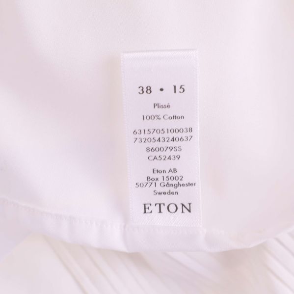 Tvättlapp med materialinformation och Eton-logotype