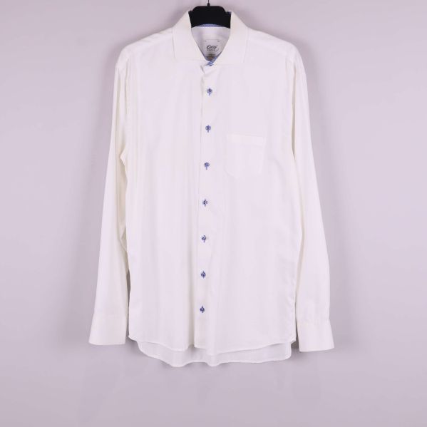 Ljus skjorta med blå knappar framifrån på galge