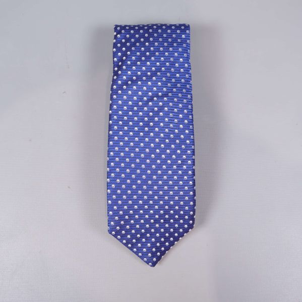 Blå slips med vita prickar, platt mot ljus bakgrund