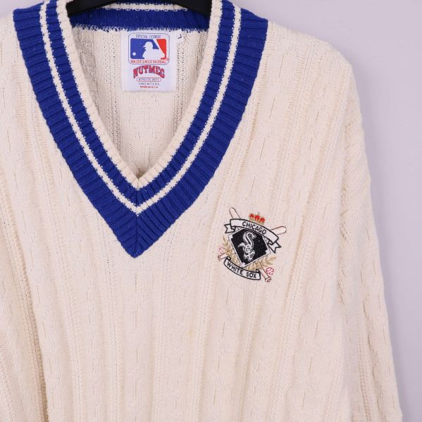 Närbild på blå V-ringning och broderad baseboll-logga