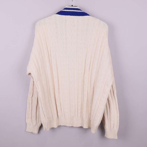 Baksidan av kabelstickad ljus tröja med blå V-ringning