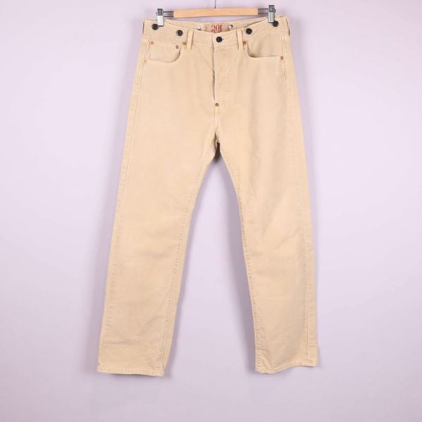 Framsida av raka beige jeans med fickor och knappgylf