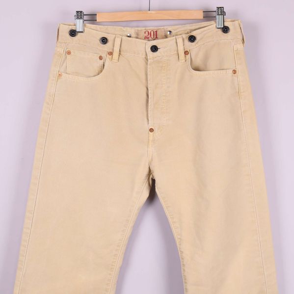 Närbild på framsidan av beige jeans och fickdesign