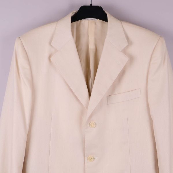 Närbild på kavajens framstycke med knappar och fickor