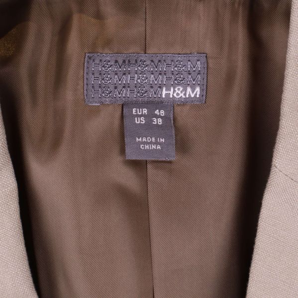 Närbild på H&M-etikett och storlekslapp EUR 48