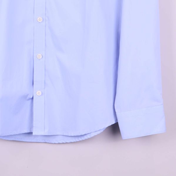 Närbild på skjortans manschett och nederkant