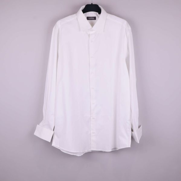 Vit långärmad skjorta hängande på galge framifrån