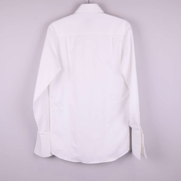 Baksidan av vit skjorta hänger på galge