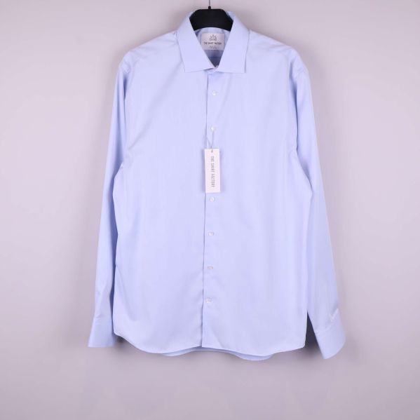 Ljusblå skjorta hänger på galge, framifrån