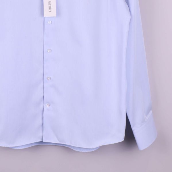 Närbild på ärmslut och nederkant av ljusblå skjorta