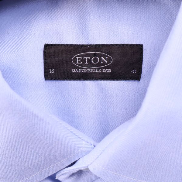 Närbild på Eton-märke i skjortans krage