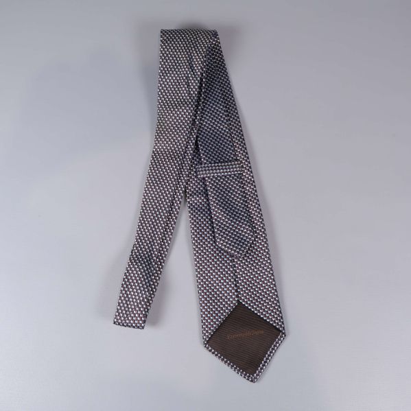 Baksida av slipsen med grafiskt mönster och mörkbrun spets