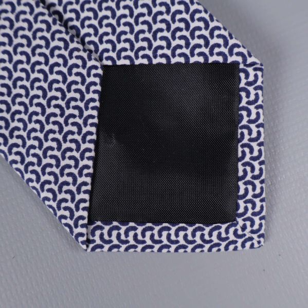 Närbild på slipsens svarta förstärkning i spetsen