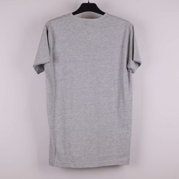 Grå t-shirt sedd bakifrån mot ljus bakgrund