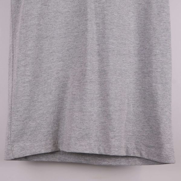 Närbild av t-shirtens nederkant i grått tyg