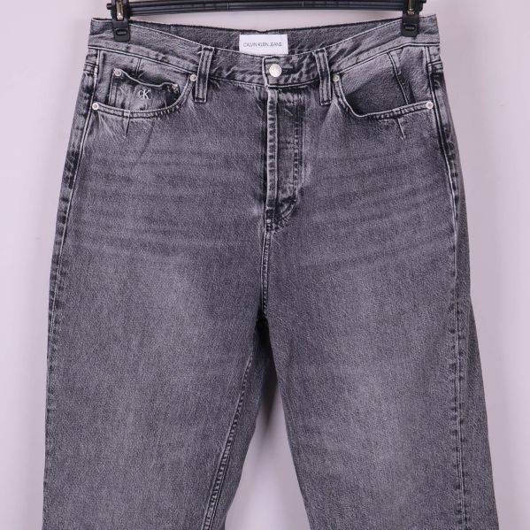 Närbild på överdel och fickor av grå jeans