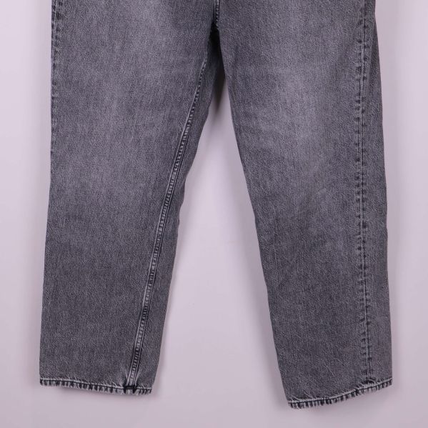 Närbild på ben och fåll av grå jeans