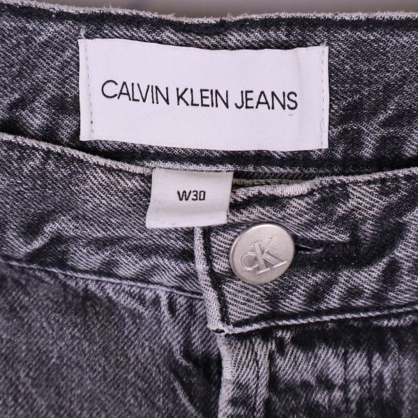 Närbild på Calvin Klein Jeans-märke och storlekslapp W30