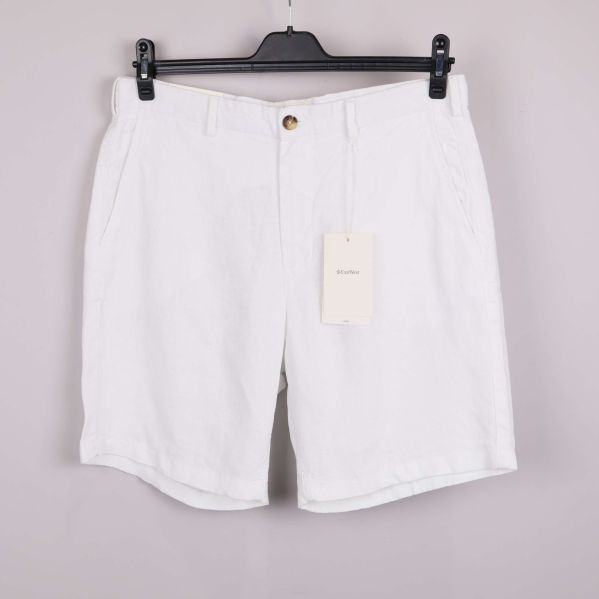 Framsidan av vita linneshorts på galge