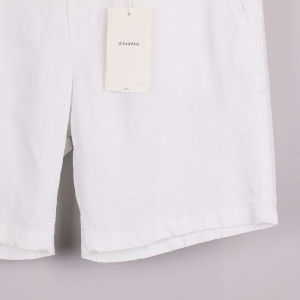 Nedre delen av vita linneshorts på galge