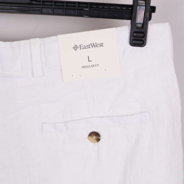 Närbild på lapp med varumärket EastWest och storlek L