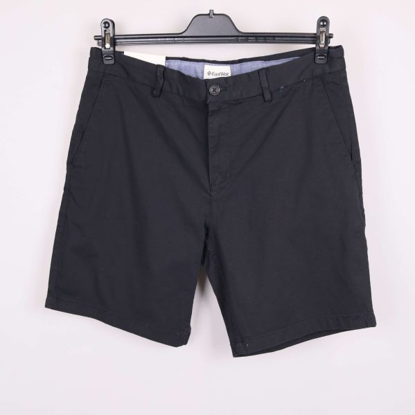 Svarta chinosshorts framifrån på galge