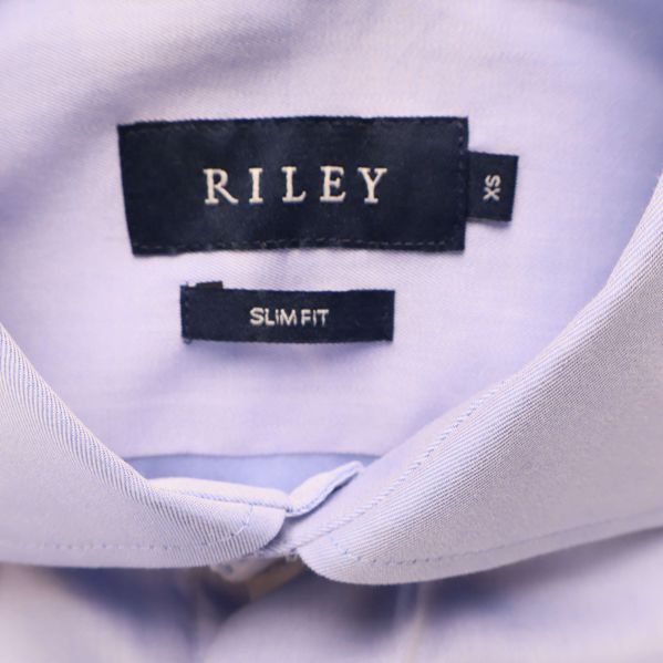 Närbild på etikett med RILEY och slim fit i kragen