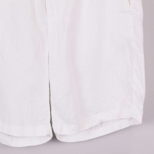 Närbild på nederkant av vita linneshorts i linne