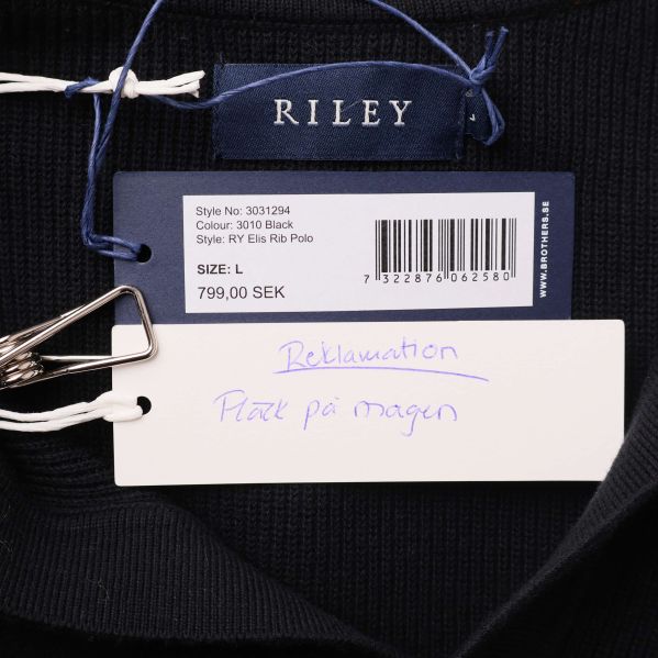 Närbild på etikett med RILEY och prislapp