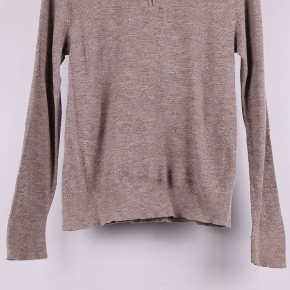 Nederkant och ribbad mudd på beige stickad tröja