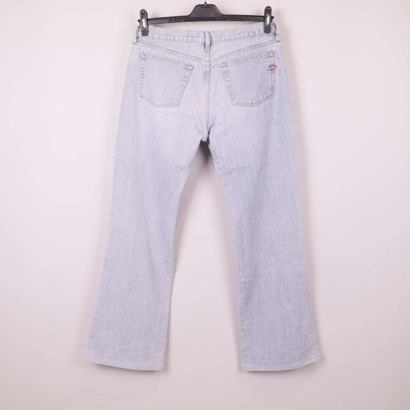 Baksida av ljusblå jeans med fickdetalj synlig