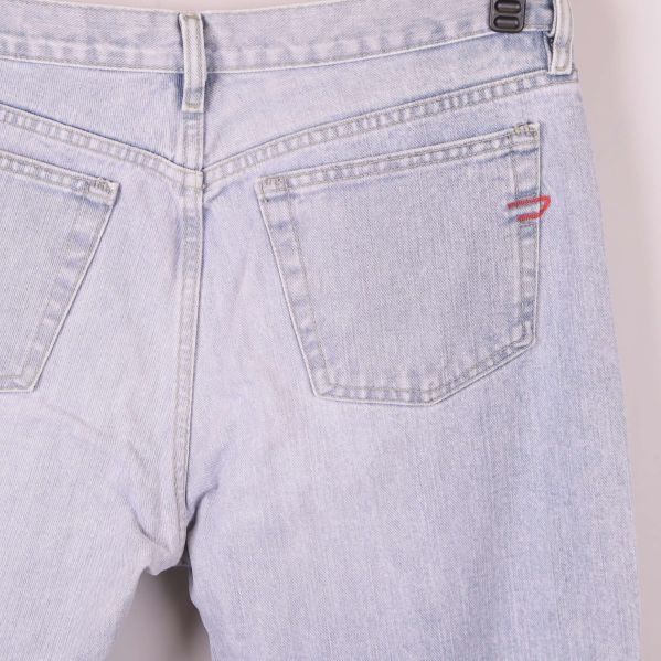 Närbild på bakficka av jeans med röd detalj