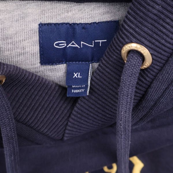 Närbild på GANT-etikett och storleksmärkning XL inuti hoodien