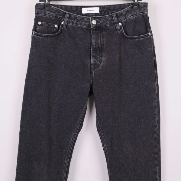 Detaljbild på framsidan av svarta jeans och fickor