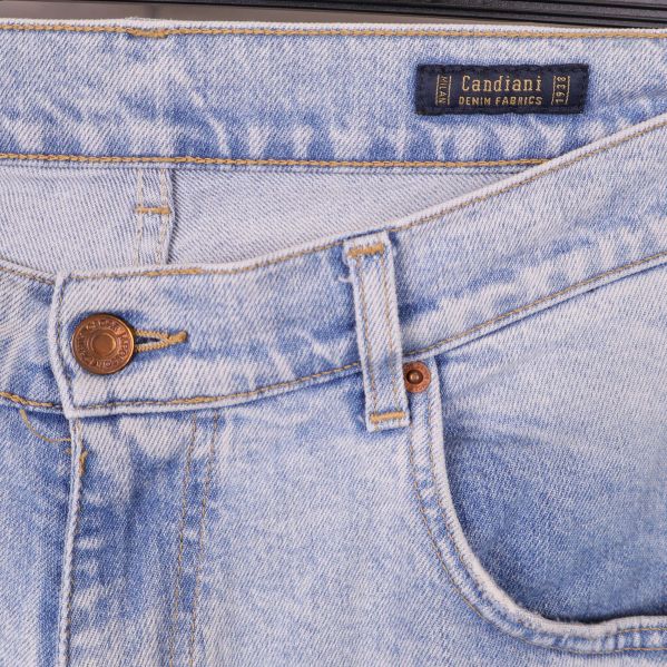 Närbild på midjan och framfickor med etiketten 'Candiani Denim Fabrics'