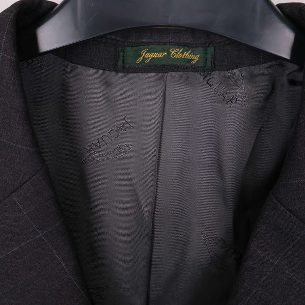 Närbild på grön etikett med märket Jaguar Clothing i kavajens krage