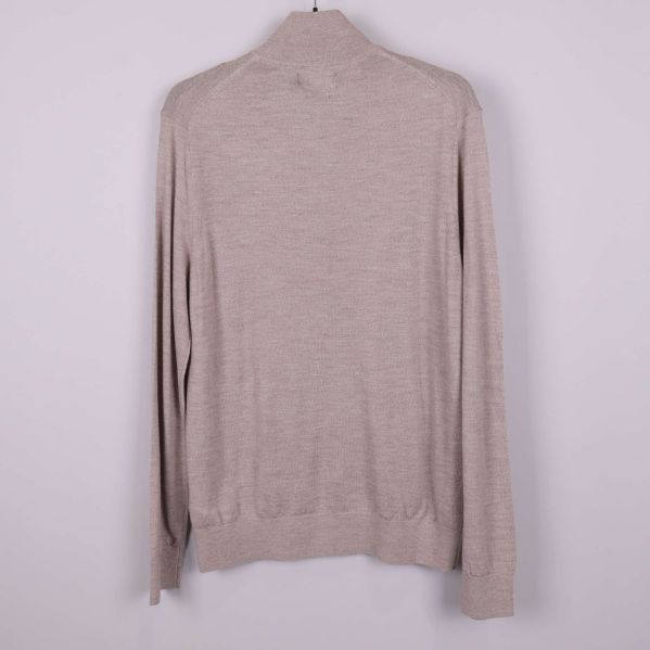 Baksidan av beige långärmad tröja med ribbade muddar