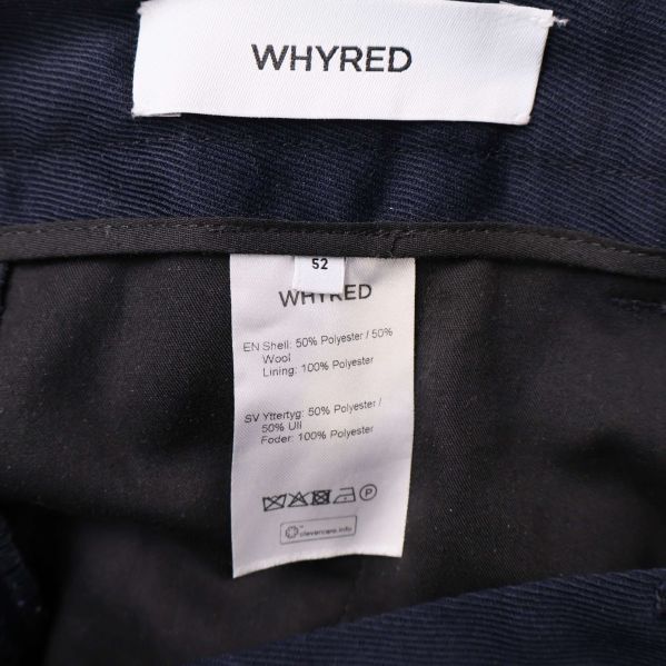 Närbild på Whyred-logga och materiallapp inuti kostymbyxa