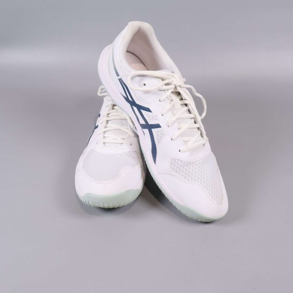 Vita sneakers poserar mot varandra i studioljus