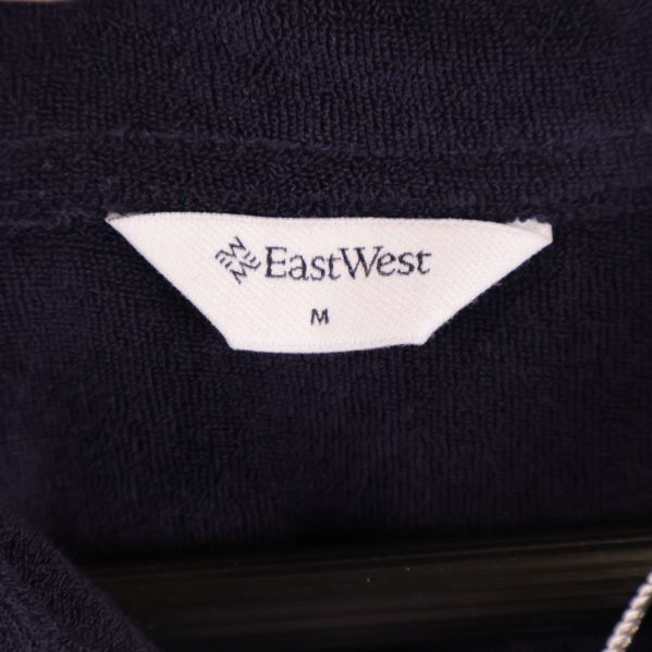 Närbild på etikett med EastWest och storlek M