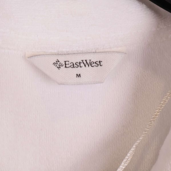 Närbild av etikett med texten EastWest och storlek M